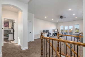 Carpeted office featuring arched walkways, ceiling fan, and recessed lighting