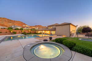 View of swimming pool featuring an in-ground hot tub, a fenced backyard, a patio area, and a mountain view