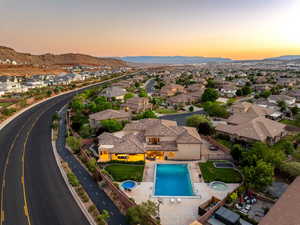 Aerial view at dusk of view of pool area, a residential view, and a mountain view