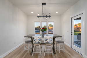 Dining space featuring light wood-style flooring, recessed lighting, and a chandelier