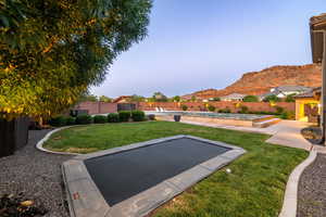 Fenced backyard featuring a mountain view and a patio area