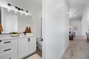 Ensuite bathroom with vanity, wood finished floors, and recessed lighting