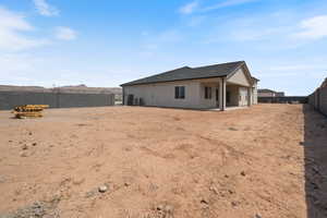 Rear view of house featuring a fenced backyard, stucco siding, and a patio area