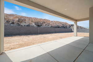 Fenced backyard featuring a mountain view and a patio area