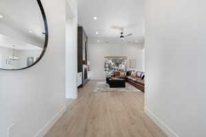Hallway featuring recessed lighting, light wood-style floors, and a chandelier