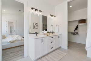 Ensuite bathroom with double vanity, recessed lighting, and tile patterned flooring