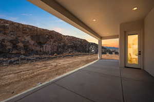 Patio terrace at dusk featuring a patio area and a mountain view