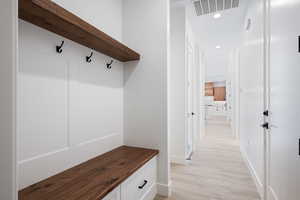 Mudroom featuring light wood finished floors and recessed lighting