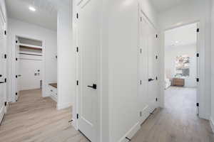 Corridor with light wood finished floors and recessed lighting