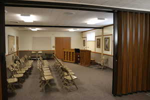 Flex-space room with carpet flooring, often used as a classroom