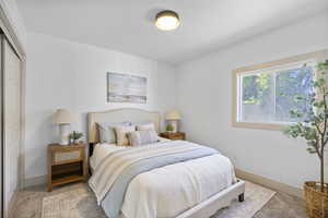 Bedroom with light carpet and a closet