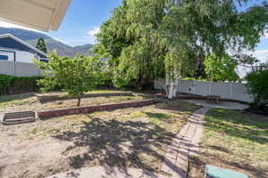 Fenced backyard featuring a mountain view