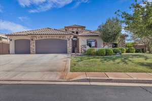 Mediterranean / spanish-style house featuring stucco siding, a garage, a tile roof, and concrete driveway