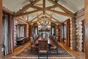Dining room featuring rustic walls, a chandelier, and hardwood / wood-style floors