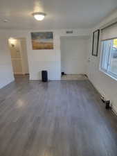 Unfurnished living room with wood finished floors and a textured ceiling