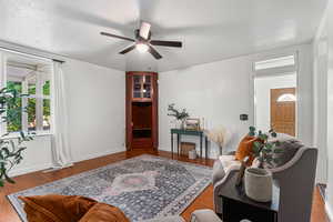 Living room with a ceiling fan, wood finished floors