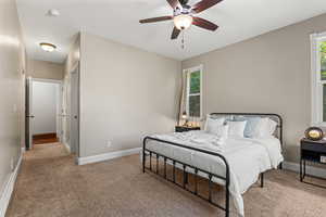 Carpeted bedroom featuring a ceiling fan