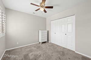 Unfurnished bedroom featuring carpet floors, a closet, and ceiling fan