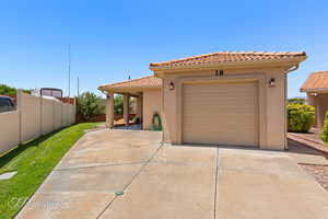 View of front facade with driveway, a tiled roof, and stucco siding