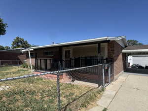 View of front facade featuring brick siding and a fenced front yard