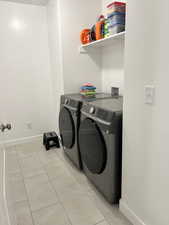 Laundry room featuring independent washer and dryer and light tile patterned floors