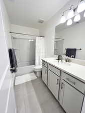 2nd full Bathroom featuring vanity, shower / tub combo with curtain, and tile patterned floors