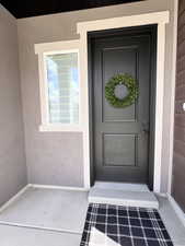 View of exterior entry featuring stucco siding