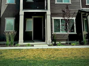 View of front of property with a balcony and a front yard