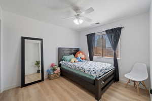 Bedroom with light wood-style floors and a ceiling fan