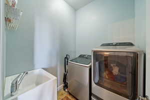 Washroom featuring washing machine and dryer and baseboards