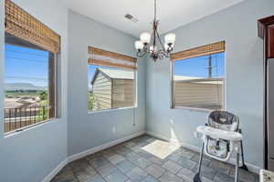Dining room featuring a chandelier and stone finish flooring