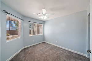 Empty room with carpet floors and a ceiling fan