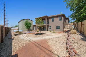 Rear view of property featuring stucco siding, a fenced backyard, and a patio