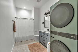 Basement bathroom and 2nd laundry featuring estacked washer and dryer, vanity, recessed lighting, and tile patterned flooring