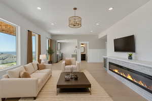 Living area featuring wainscoting, recessed lighting, a decorative wall, light wood-style floors, and a fireplace