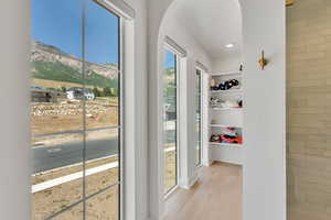 Doorway with light wood-style flooring, a mountain view, arched walkways, and recessed lighting