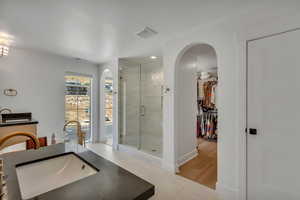 Bathroom featuring a stall shower, tile patterned flooring, a walk in closet, recessed lighting, and a tub
