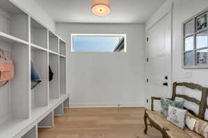 Mudroom with light wood-style flooring and baseboards