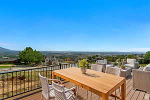 Deck featuring outdoor dining space, a mountain view, a residential view, and an outdoor living space