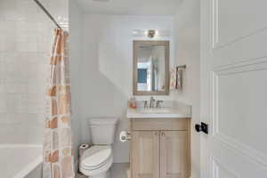 Bathroom featuring vanity and shower / bathtub combination with curtain