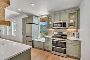 2nd basement kitchen with stainless steel appliances, cabinetry, light countertops, and recessed lighting