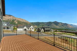 Wooden terrace featuring a residential view, a mountain view, and concrete driveway