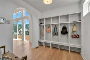 Mudroom with wood finished floors and arched walkways