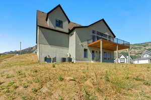 Back of property featuring stucco siding and a deck with mountain view