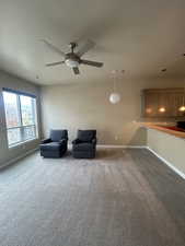 Living area with carpet floors and ceiling fan