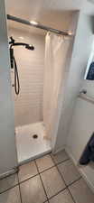 Bathroom with a stall shower and tile patterned flooring