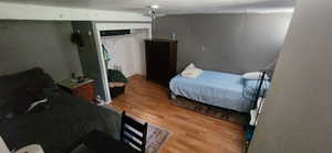 Bedroom with light wood-style flooring, radiator, and a closet