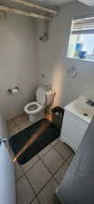 Half bath with tile patterned flooring and vanity