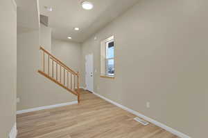 Entryway featuring light wood-style floors, stairway, and recessed lighting