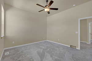 Carpeted spare room featuring ceiling fan and a smoke detector